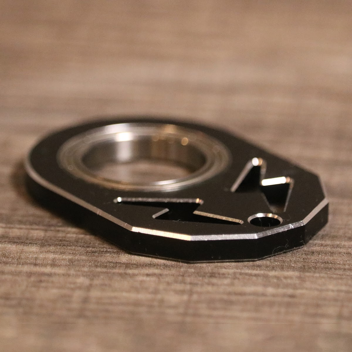 KeyKaram key spinner in black — angled close-up showing bearing and lightning bolt cutout detail